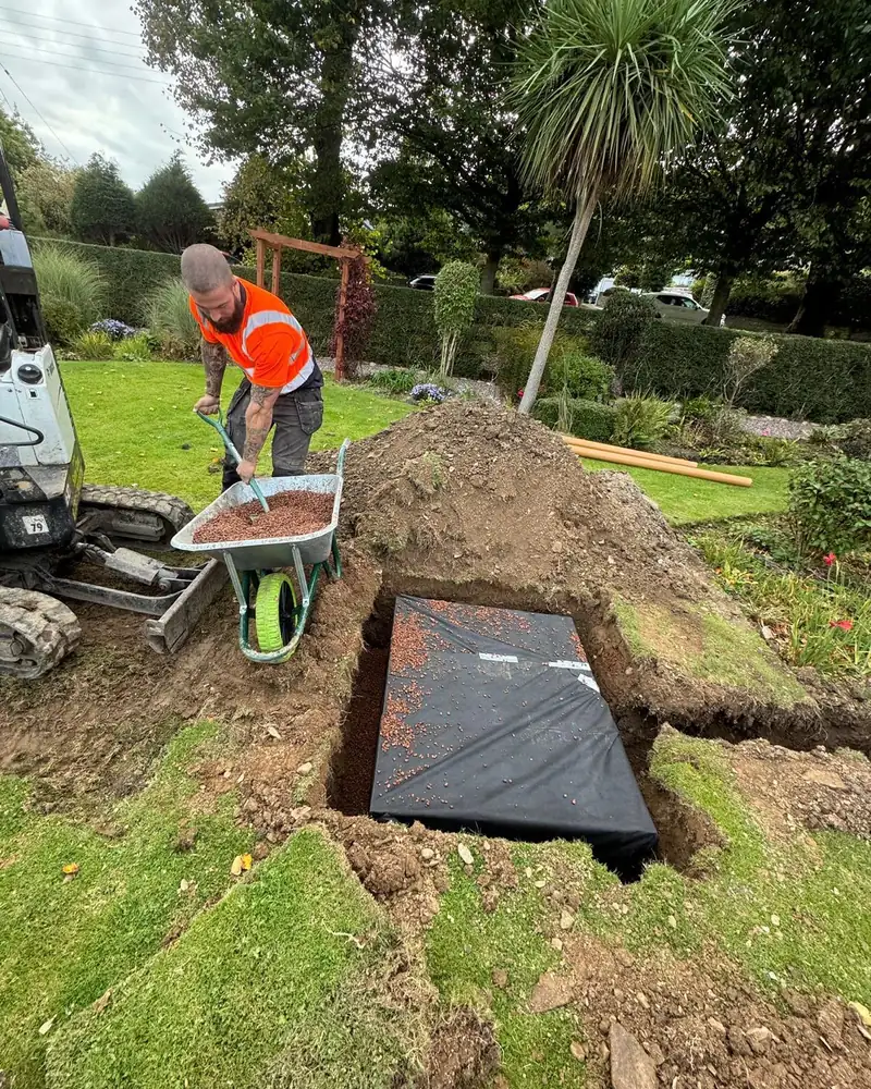 Easy Flow Drainage Solutions engineer backfilling a new soakaway in a customer's garden